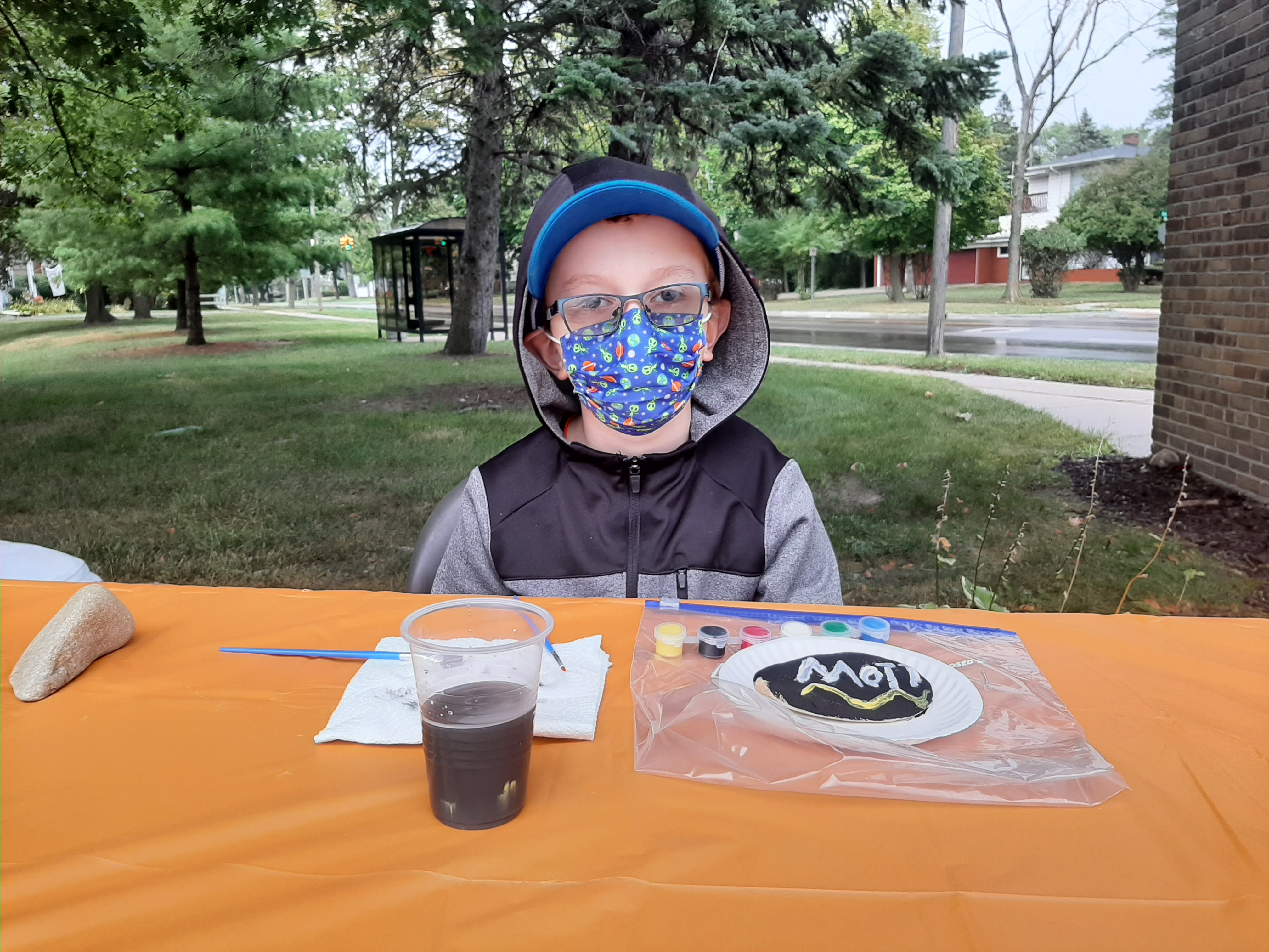 Young patron painting a rock for the MCC Centennial