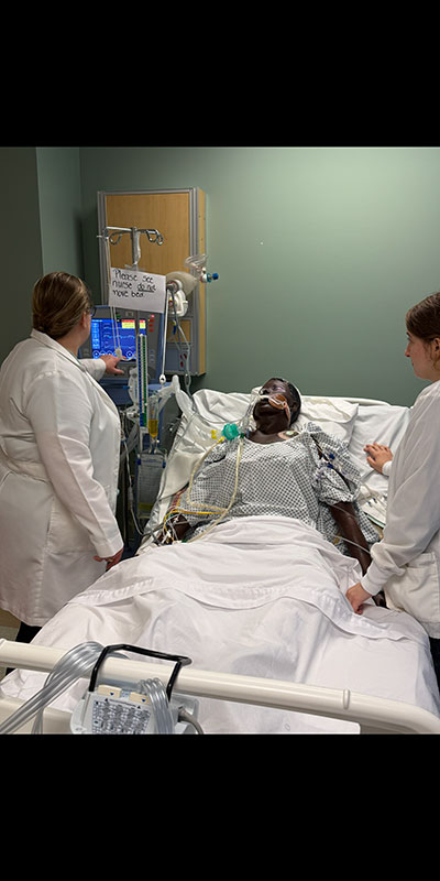 Two women monitoring SIM mannequin patient
