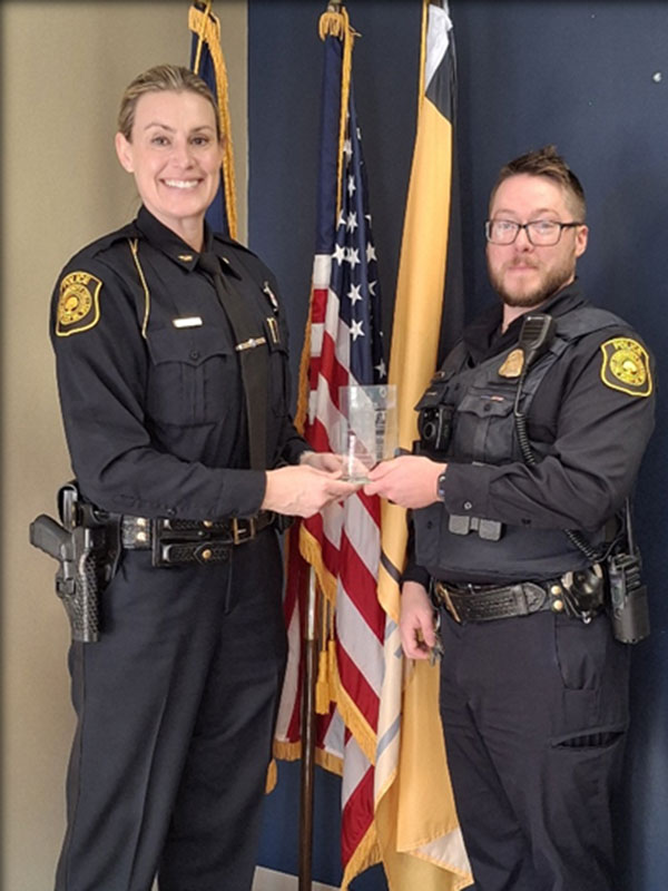 Kyle Hoffman holding award with Chief Jamie Zechman