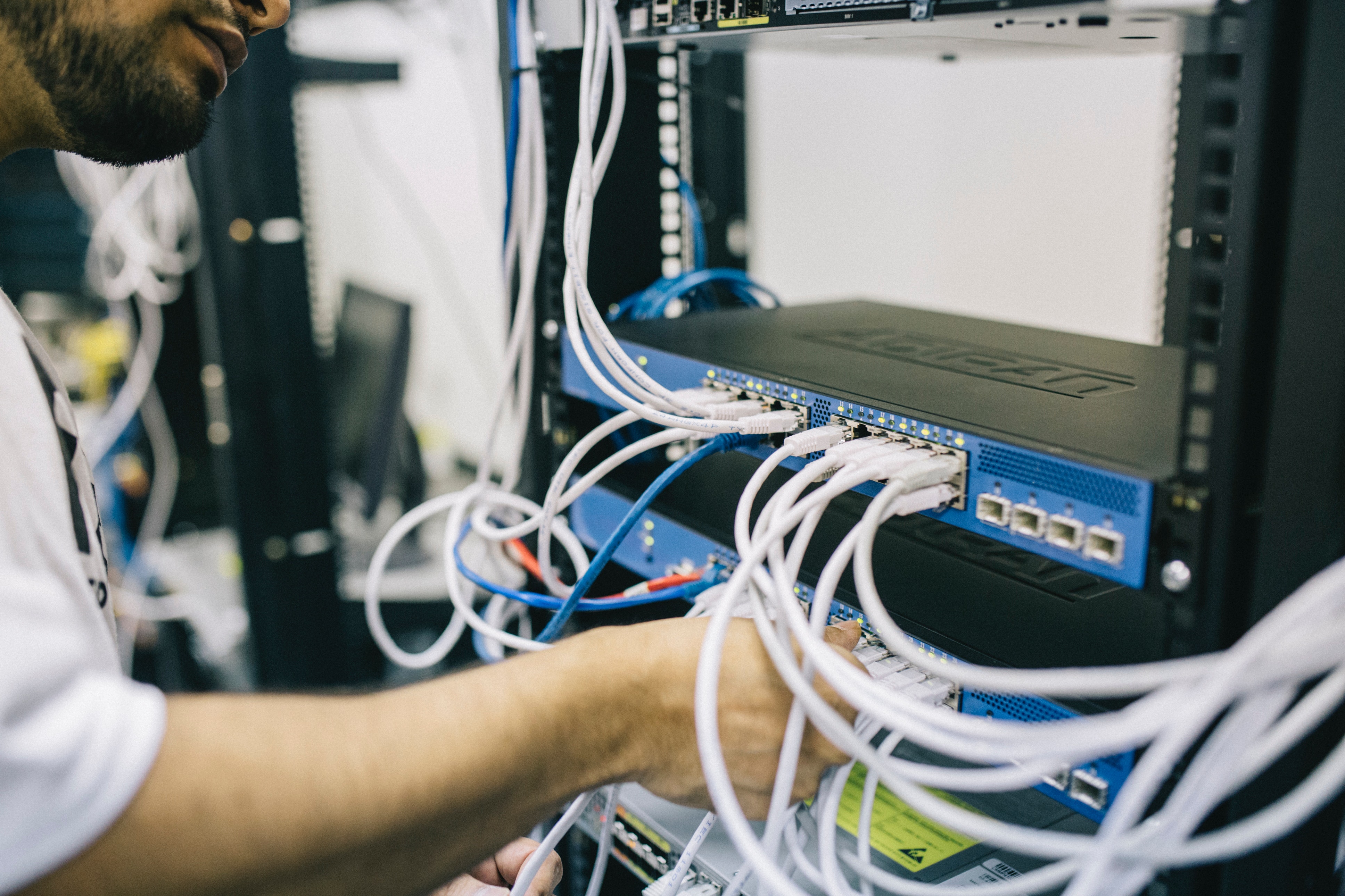 Network cable in rack with person's hand