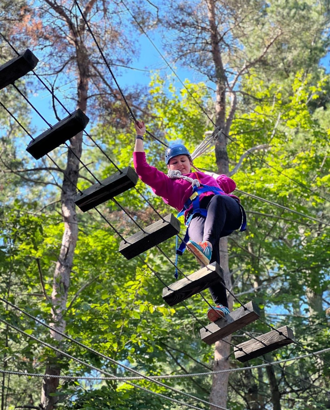 Honor student walking across a rope/ladder bridge