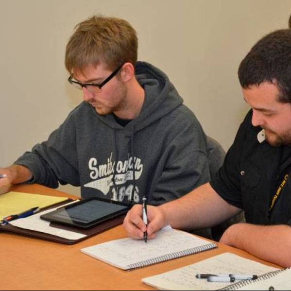 two male students doing classwork