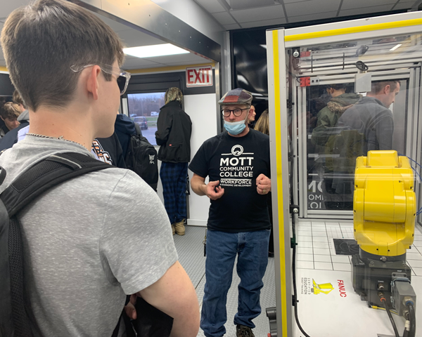 Presenter discussing featured lab equipment with a student.